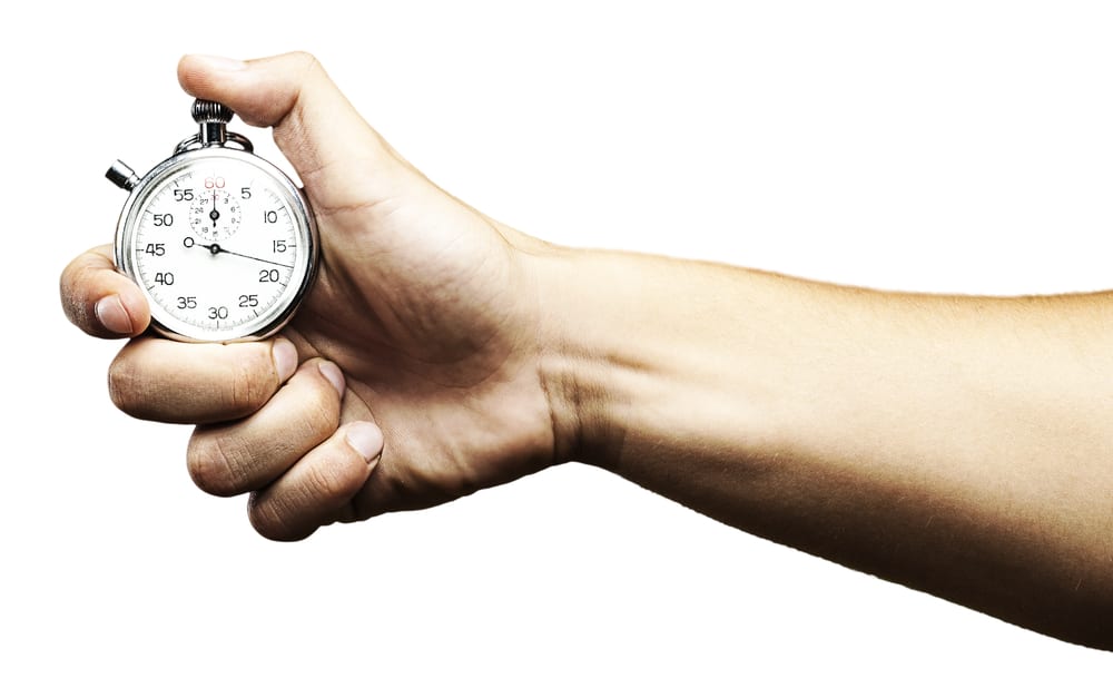 Hand holding stopwatch, white background