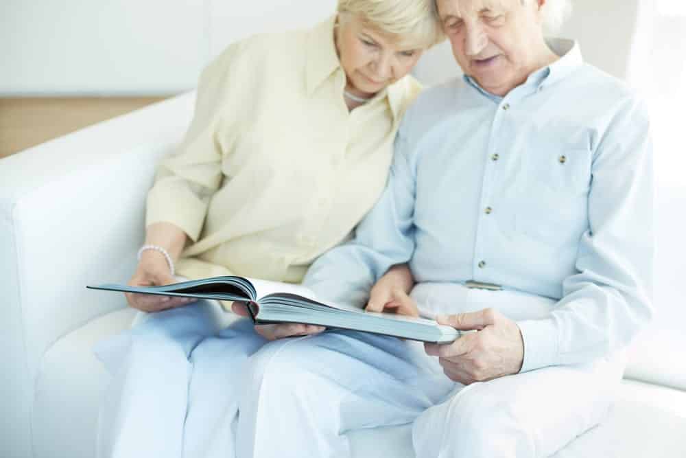 Senior couple on couch looking at book