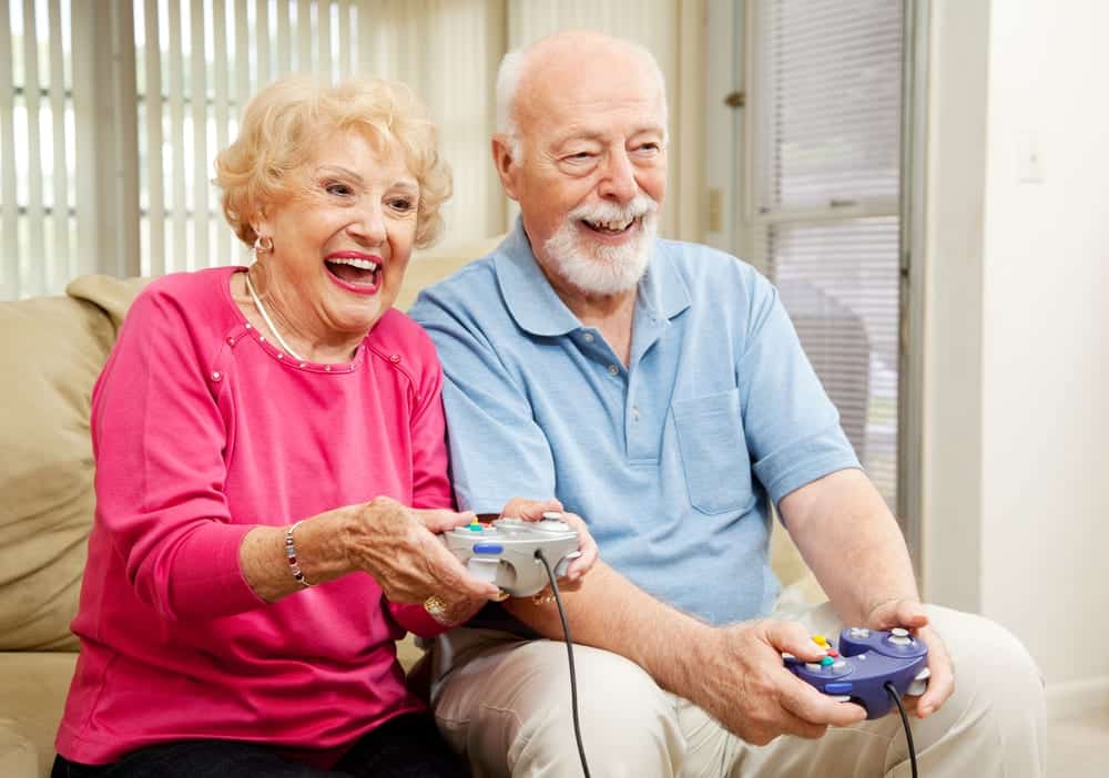 Smiling senior couple playing video game