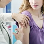 Close-up-of-young-woman-receiving-vaccination-in-arm